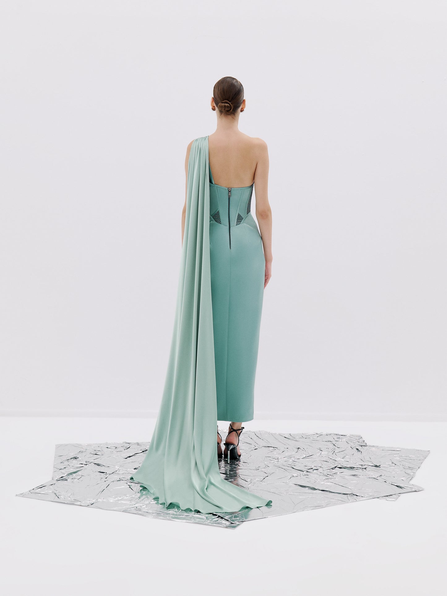 One shoulder gown with corset bodice and high slit.