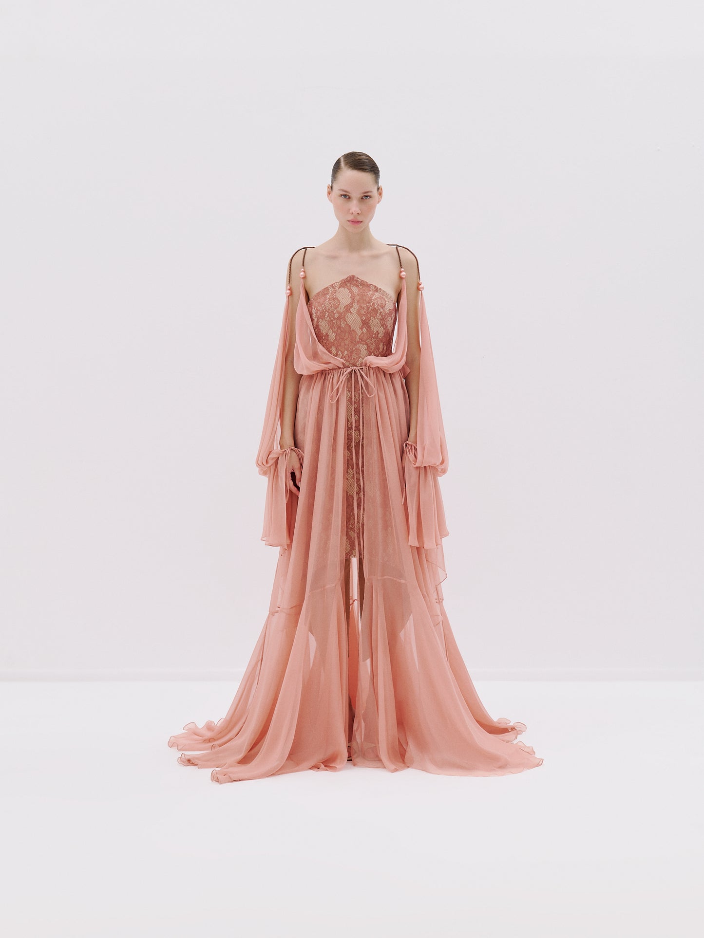 Blush pink lace gown with sheer drapes.