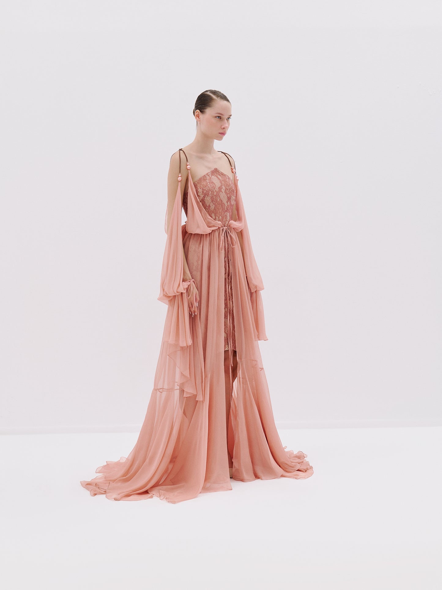 Blush pink lace gown with sheer drapes.