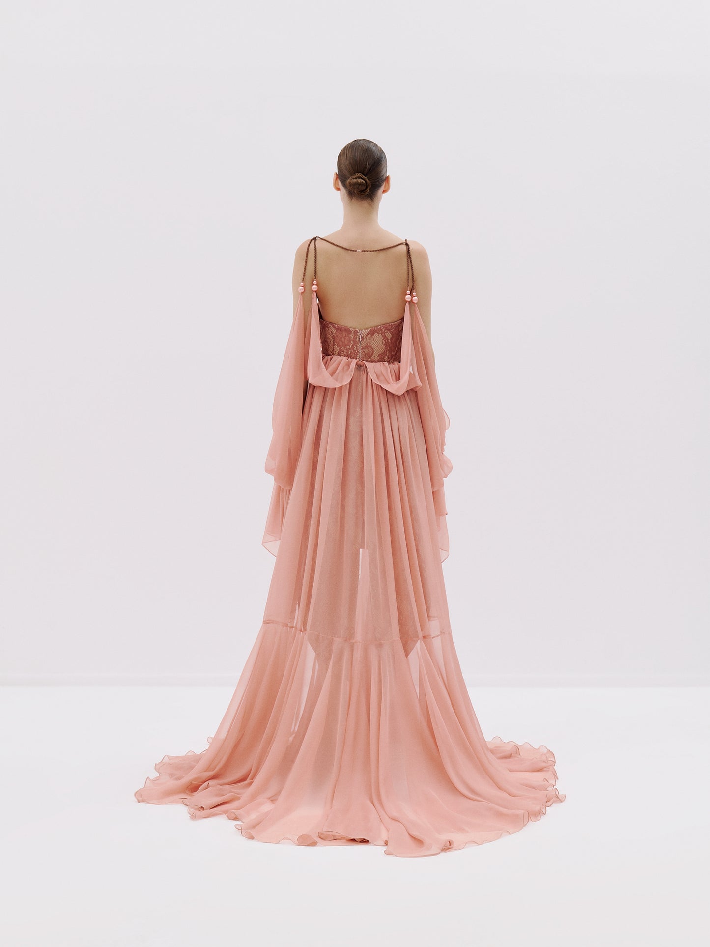 Blush pink lace gown with sheer drapes.